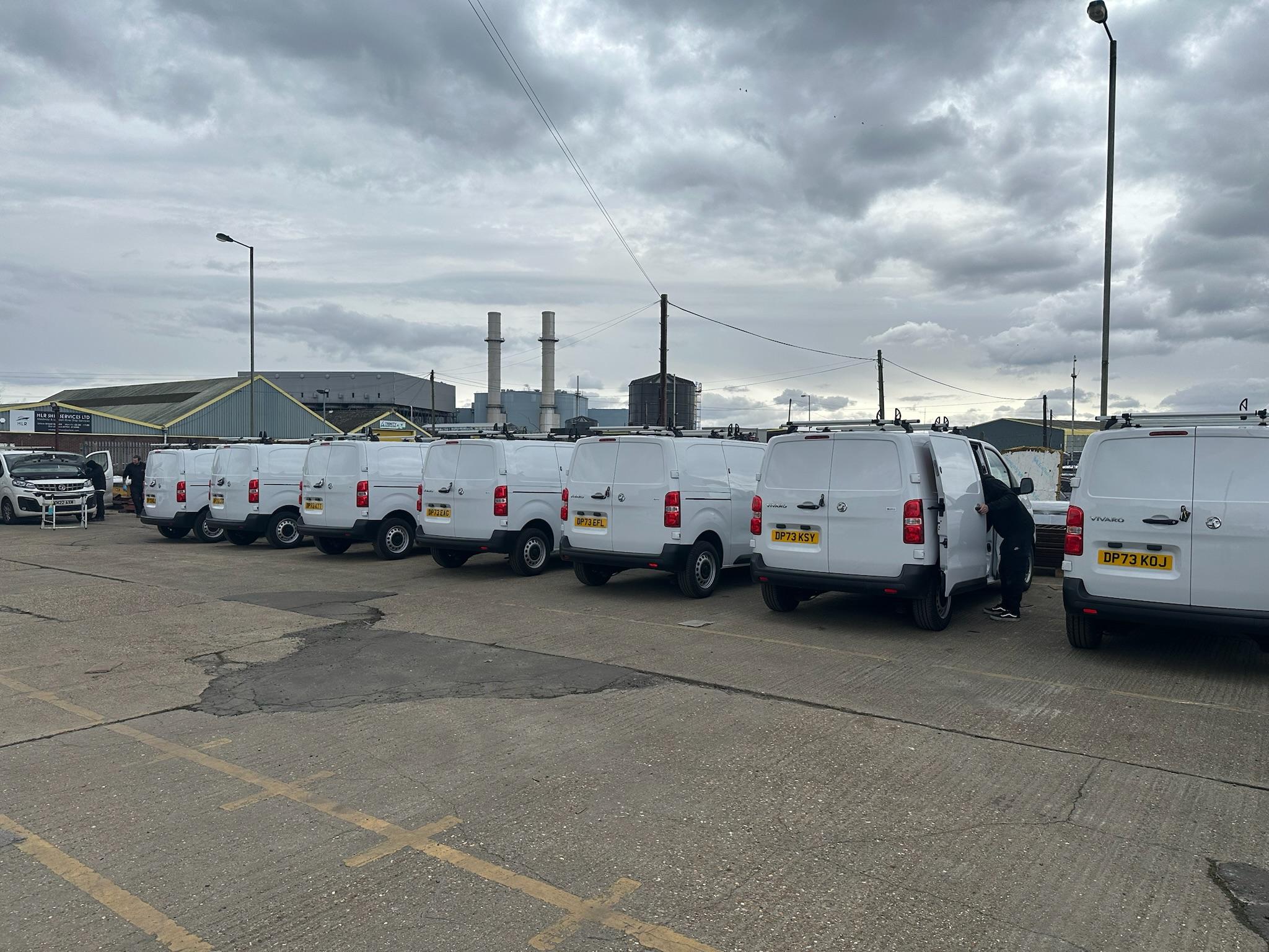Row of white commercial vans fitted out for fleet customer