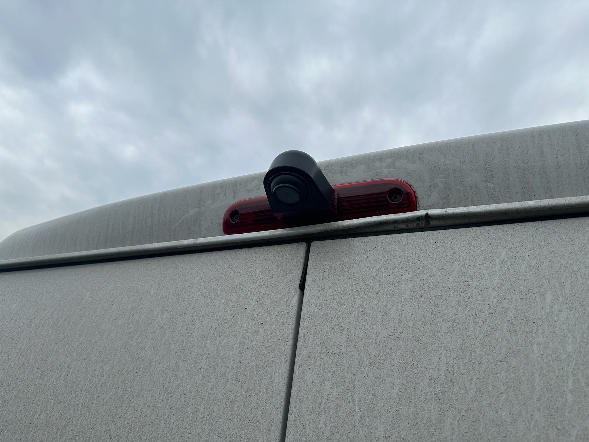 Reverse camera mounted in brake light housing on van rear